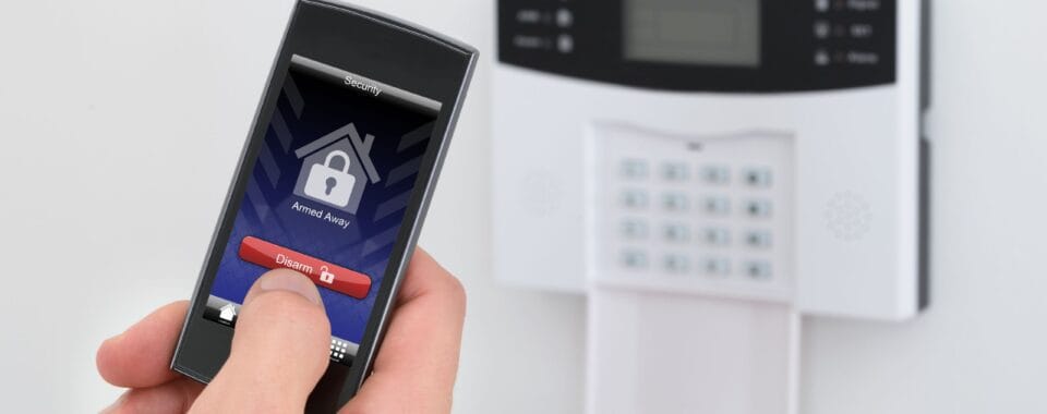Professional technician installing a modern smart home security system with doorbell camera and control panel in a Toronto residence