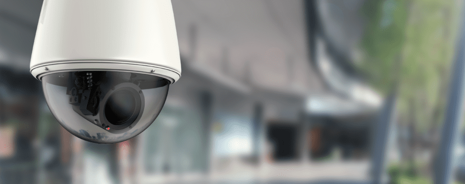 Professional security camera installer setting up outdoor surveillance system